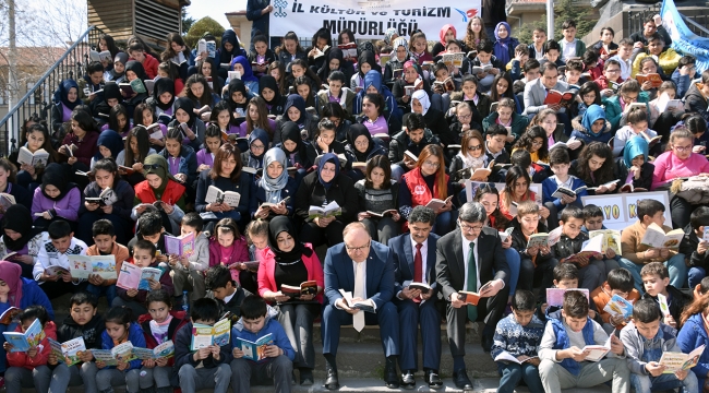 Kitap okumak için merdivenlere oturdular